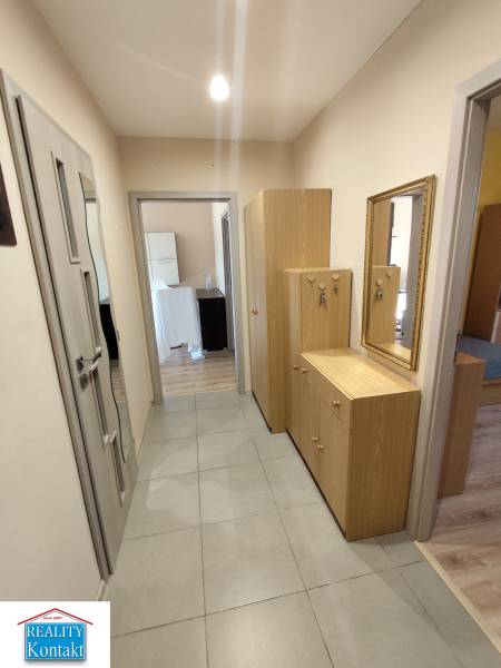 A hallway with a tiled floor and wooden furniture in a 3-room apartment.