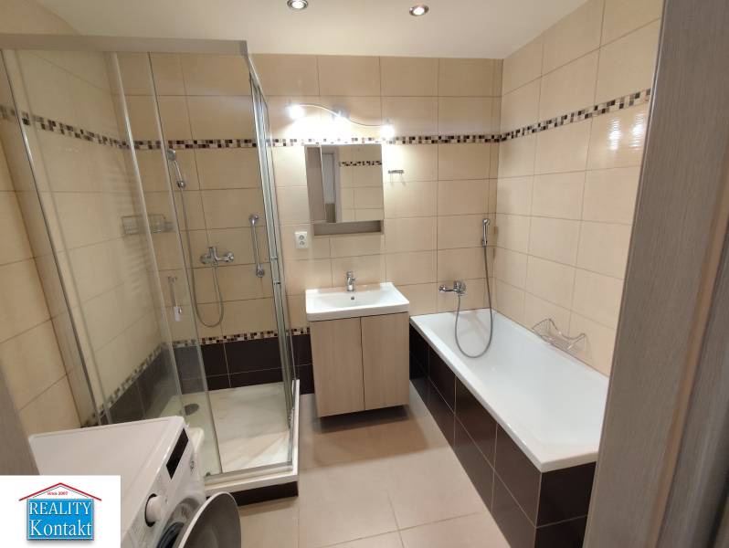 A bathroom in a 3-room apartment with a shower and a bathtub, light tiles.
