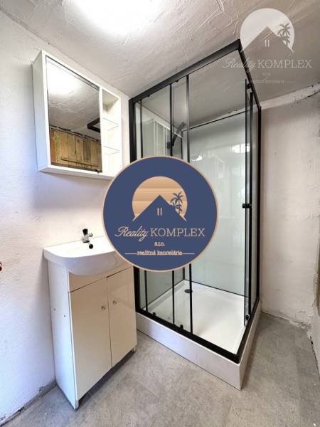 Bathroom in a cabin with a sink and a shower on a light-colored floor.