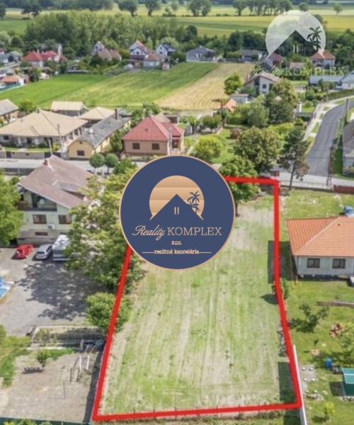 A residential plot in Čiližská Radvaň, surrounded by houses and greenery, offers beautiful views.