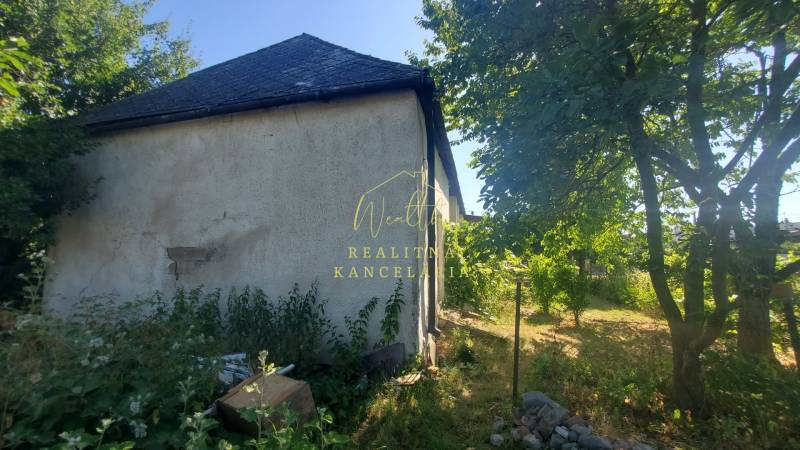 A family house on Mostová Street in Sečovce with a large garden and trees.