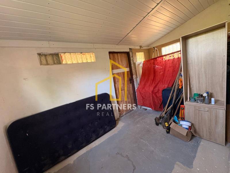 A room with cabinets, tools, and a red cloth on the wall, looks like a storage space.