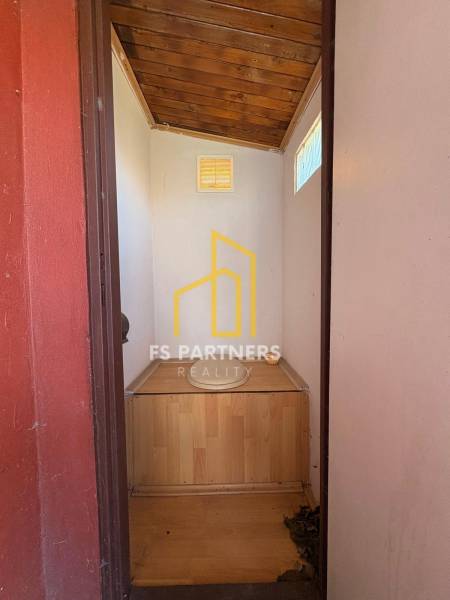 A wooden interior of a simple room with light walls, windows, and ground-level garden motifs.