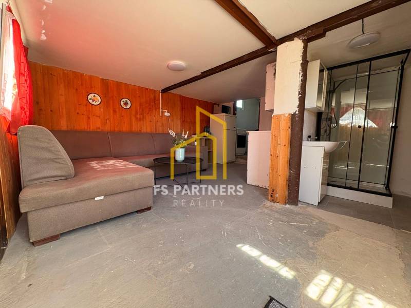Interior with seating, shower corner, and kitchenette in the Gardens.