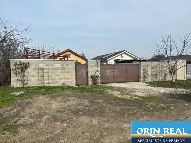 In Zálesí on Domky Street, there is a closed gate and a concrete fence surrounding agricultural and forest land.