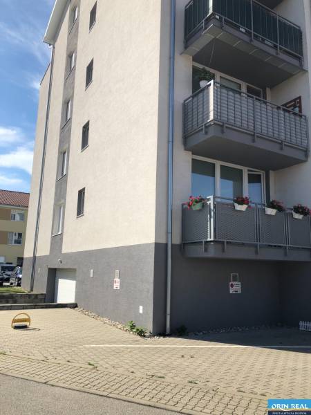 A four-story building with balconies and a garage on Rastislavova Street in Slovenský Grob.