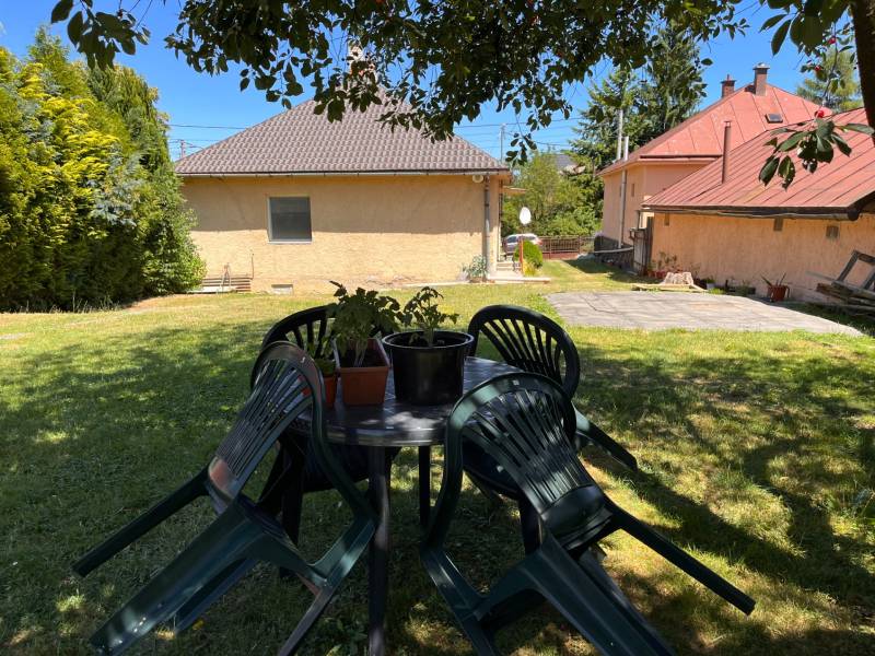 The garden of a family house in Slovenská Kajňa with a plastic table and chairs.