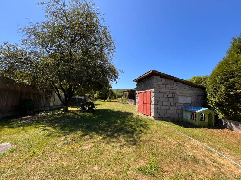 The garden of a family house in Slovenská Kajňa with a shelter and a tree.
