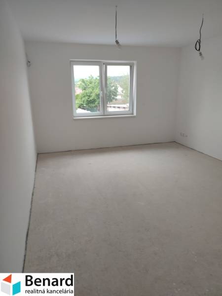 A spacious, bright room in a family house, white walls and a large window.