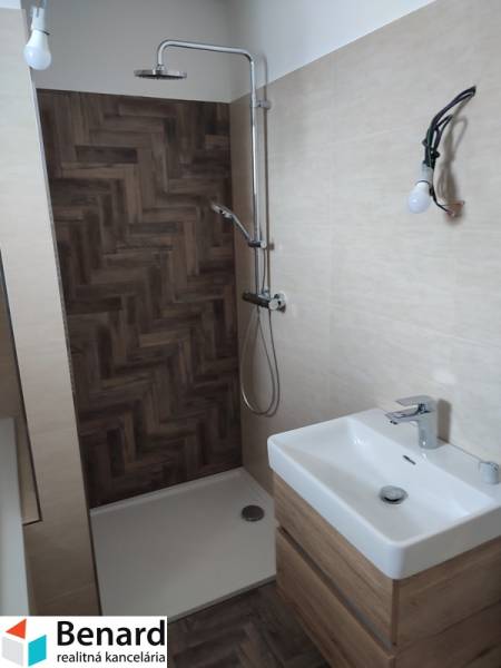 A bathroom in a family house with wooden paneling and a shower enclosure.