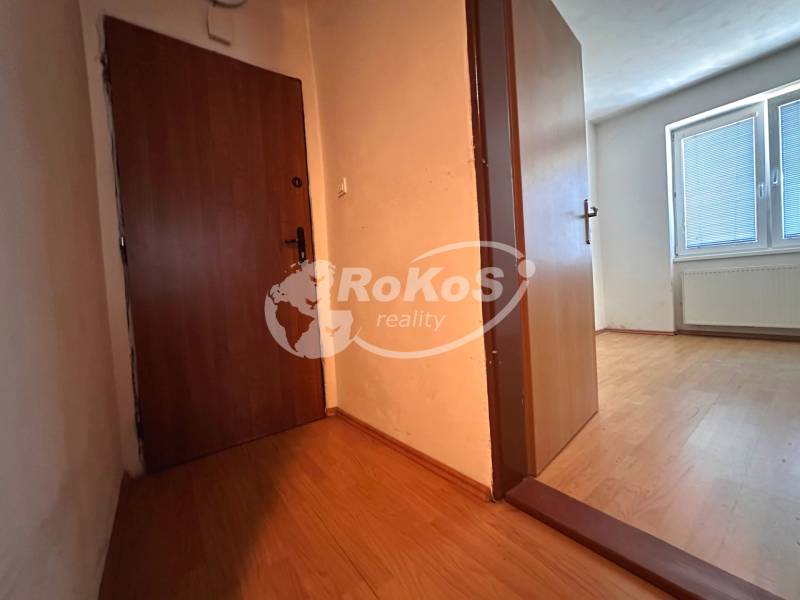 Entrance hallway of a 3-room apartment with wooden doors and a view into the room.