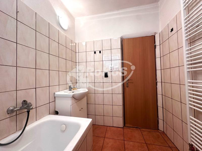 A bathroom with a bathtub and a sink in a 3-room apartment.