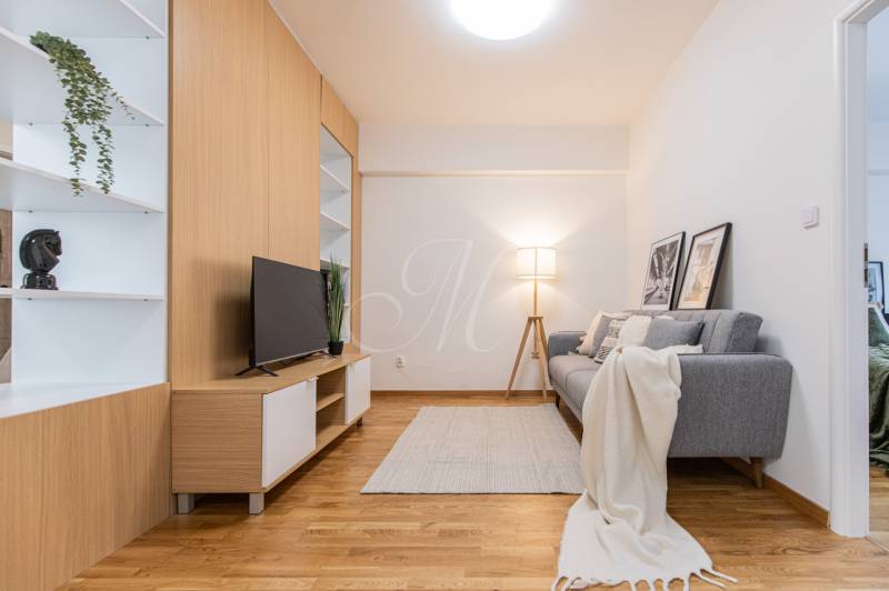 Living room with a TV, gray sofa, and decorative elements in a 3-room apartment.