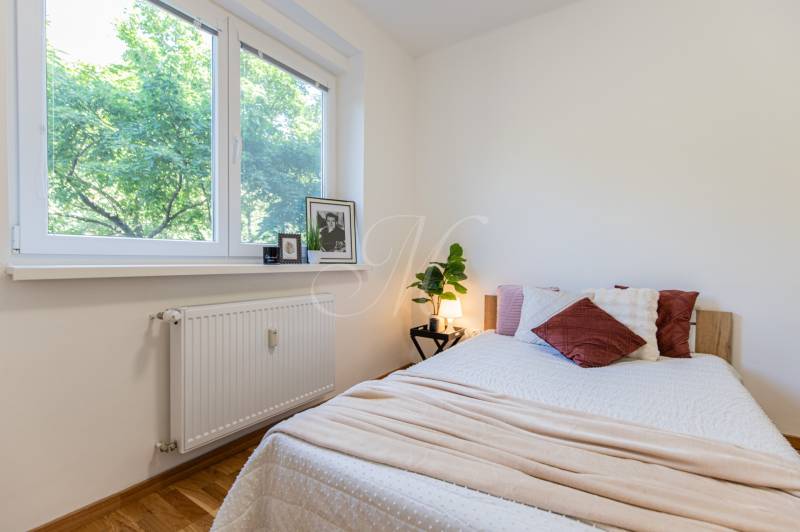 A bedroom in a 3-room apartment with a window, a bed, and decorations on the windowsill.