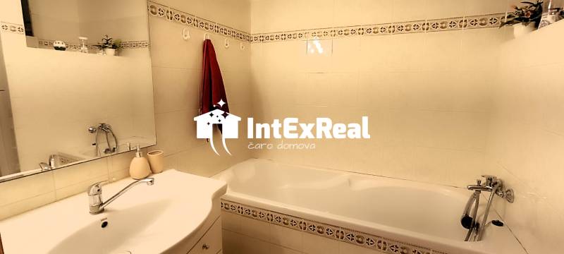 Bathroom in a 3-room apartment with a sink, mirror, and bathtub.