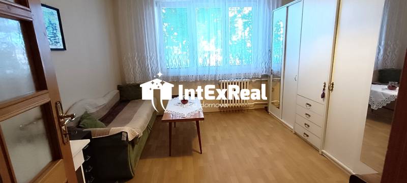 A room in a 3-room apartment with a sofa, a table, and a large wardrobe.