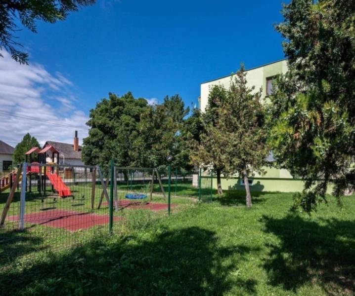 A children's playground with climbing frames and a slide in the town of Číčov near a one-bedroom apartment.