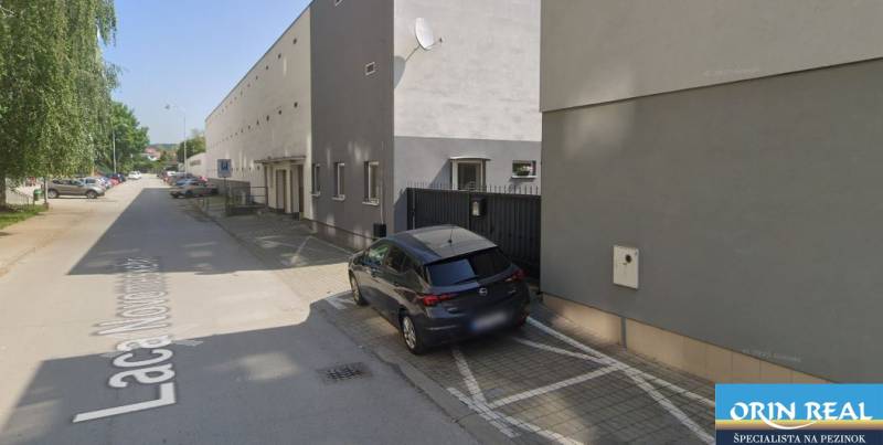 Cars parking near the building on Laco Novomeský Street in Pezinok, near the garages.