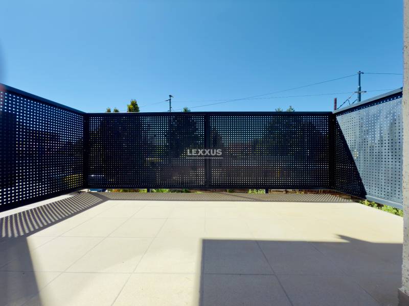 A bright terrace with perforated railing in a 2-room apartment, sunny day.