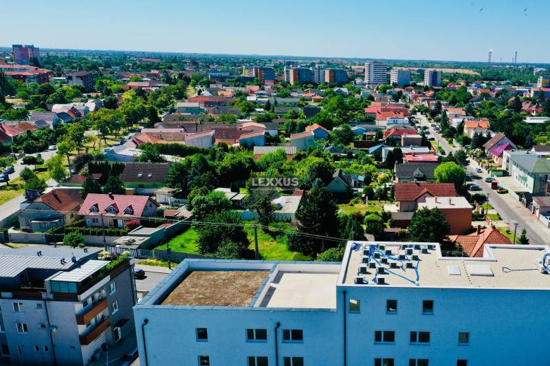 View of Bratislava-Podunajské Biskupice from Geologická, showing the surrounding houses and greenery.