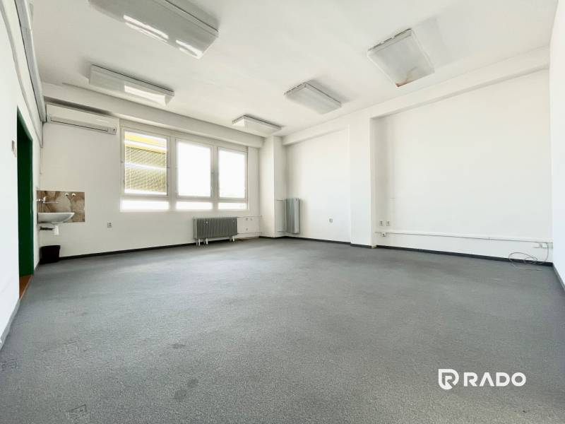 Spacious offices with a sink, large windows, and a radiator.
