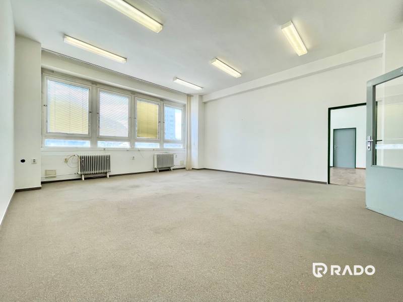 A bright room in offices with large windows and radiators.