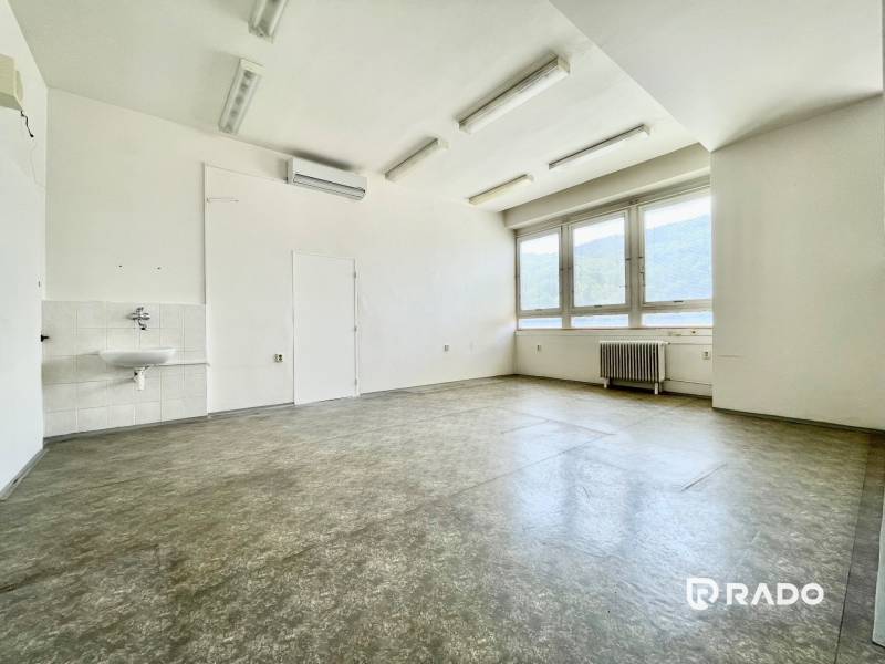 Bright office spaces with a sink and large windows.