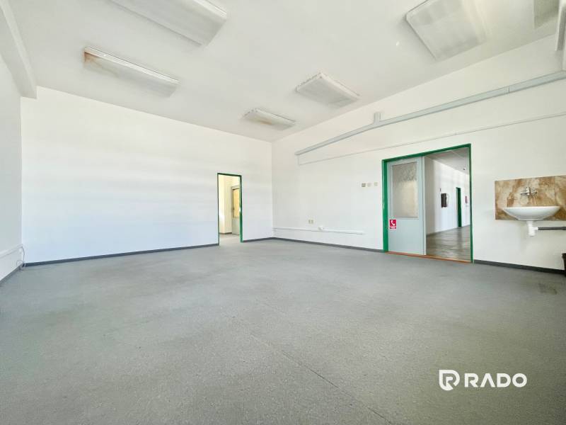 Spacious offices with a sink, bright lighting, and neutral colors.