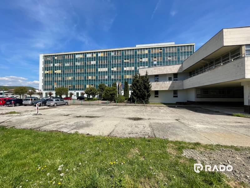 Office building on K výstavisku Street in the city of Trenčín with parking and greenery.