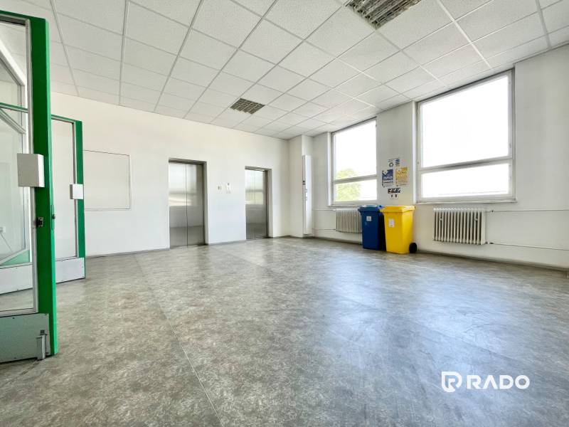 Offices with elevators, recycling bins, and radiators, bright space.