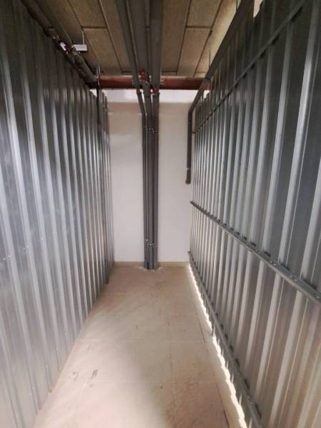 Storage space in a 2-room apartment with metal walls and pipes.