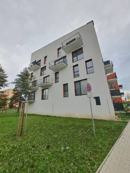 An apartment building on Jilemnického Street in Svit, surrounded by greenery and a walkway.