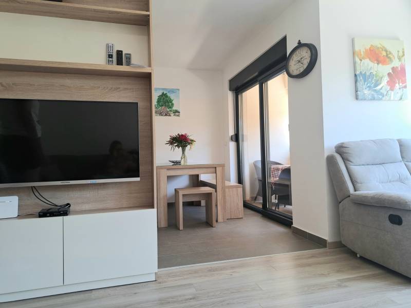 Living room in a 3-room apartment with a television and a comfortable armchair.