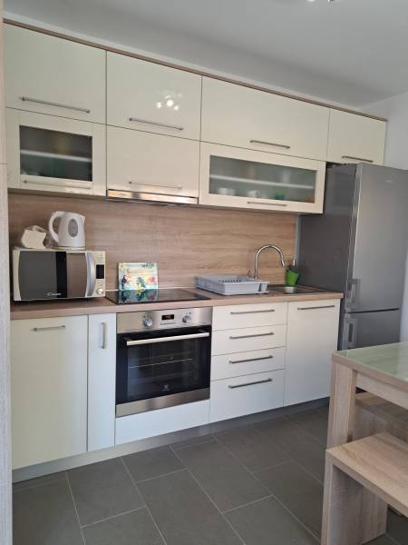 A kitchen in a 3-room apartment with light cabinets and stainless steel appliances.