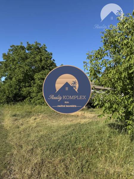 Lands - housing in the village of Povoda, green areas and trees under the blue sky.