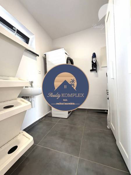 Laundry room in a family house with a washing machine and a washing area.