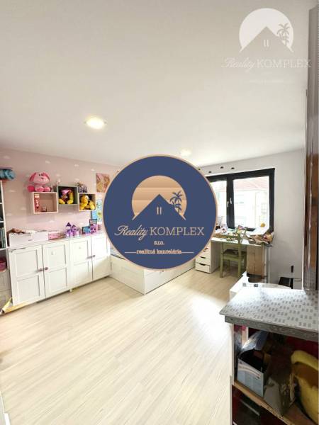 Children's room with toys in a family house, light flooring and storage cabinets.