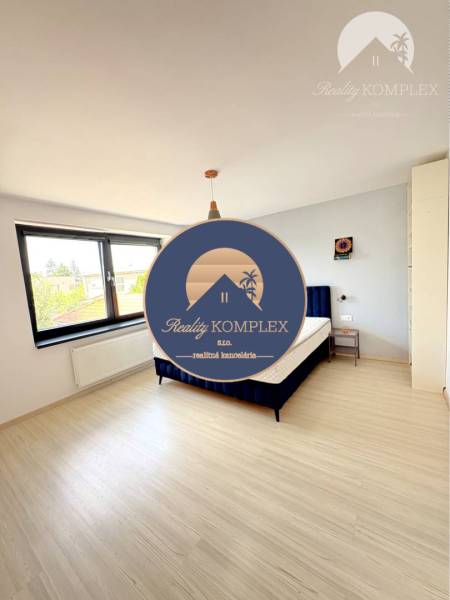 A bright room with a bed and large windows in a family house.