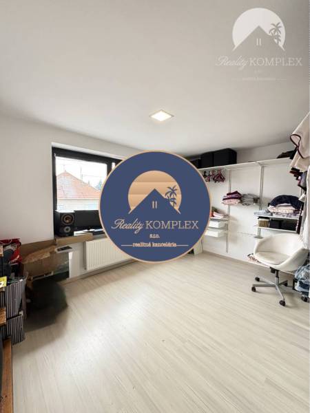 Room in a family house with storage shelves and a chair.