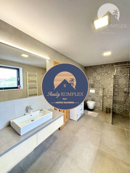 A bathroom in a family house with ceramic tiles and a shower corner.