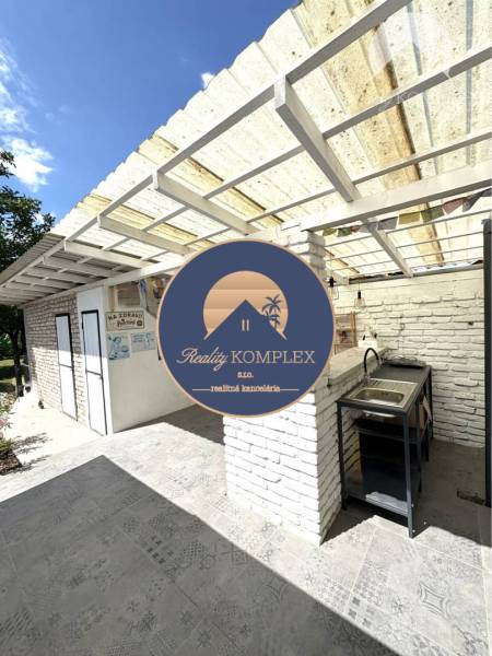A family house in Komárno with a terrace, covered pergola, and outdoor sink.