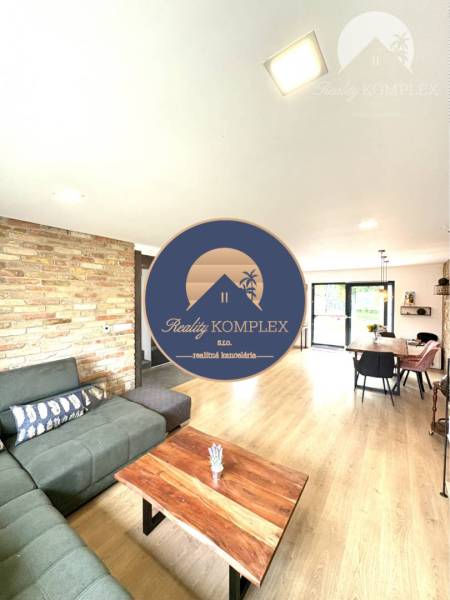Living room in a family house with a brick wall and a wooden table.