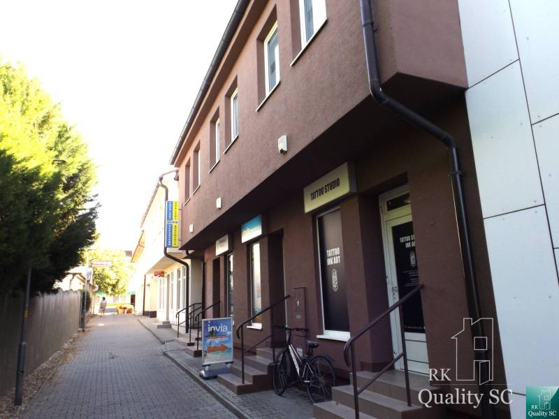 The building on Mäsiarska Street in Senec with studios and shops along the sidewalk.
