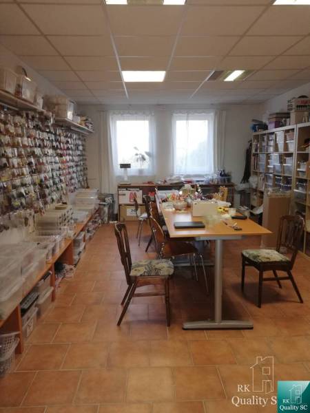 The interior of a building with tables and shelves full of materials for creative activities.