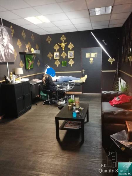 Interior of a building with a tattoo parlor, gold-colored decorations on the walls.