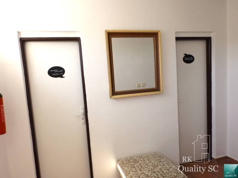 The interior of a building with two doors, a mirror, and a fire extinguisher.
