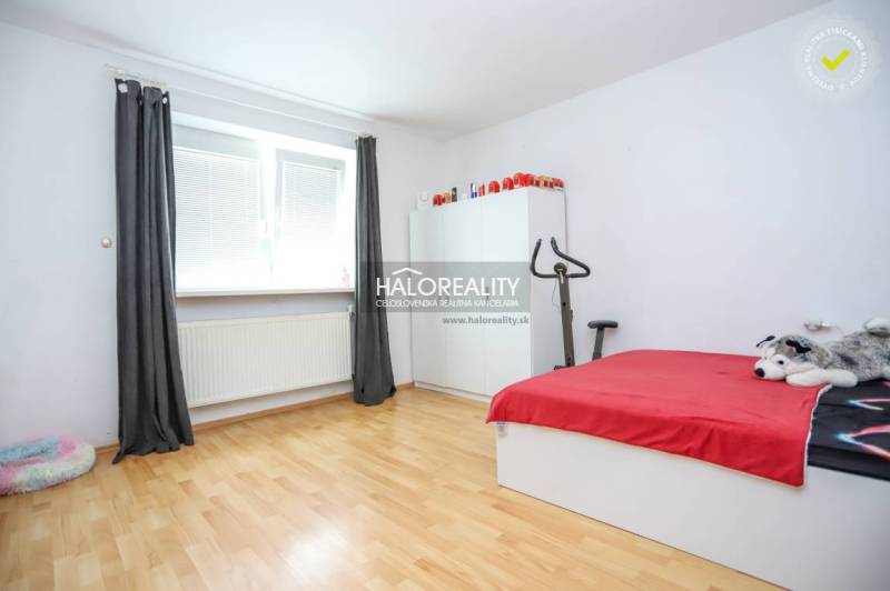 A room in a family house with a bed, a wardrobe, and exercise equipment.