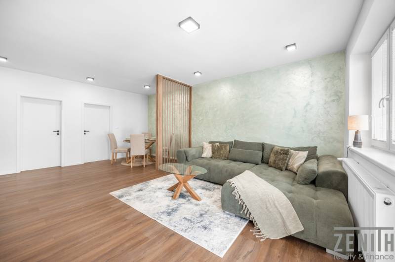 Living room in a 3-room apartment with a sofa, dining table, and wooden floor.