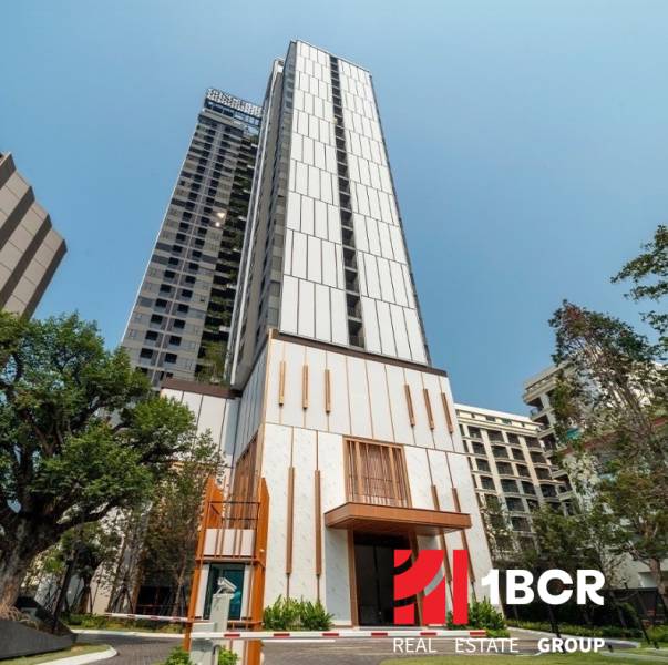 Apartment construction in Pattaya, a high-rise building with modern architecture and greenery around.