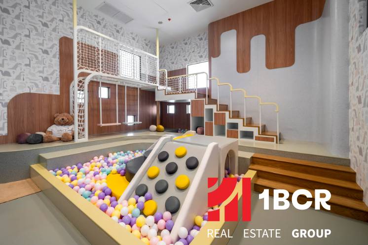 A play corner with balls and a slide in the premises of apartment construction.